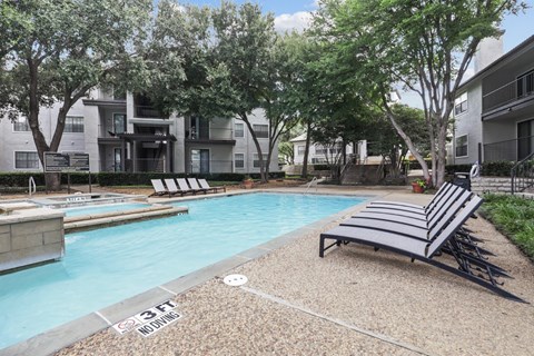 a swimming pool and lounge chairs at Jefferson Creek in Irving, TX